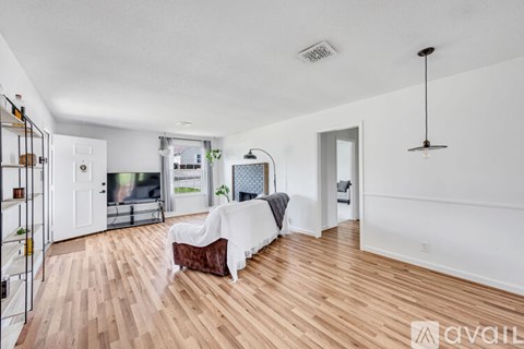 A living room with a white couch and a wooden floor.