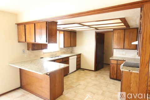 A kitchen with wooden cabinets and a granite countertop.