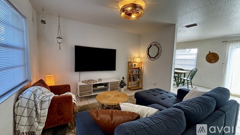 A living room with a television, a couch, a chair, and a coffee table.