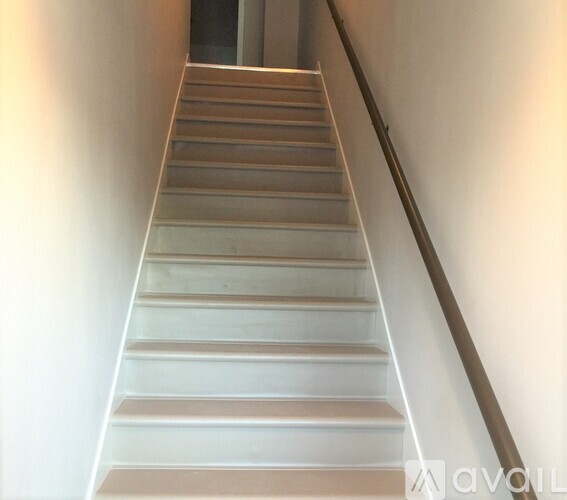 A staircase with a metal railing on the right side.