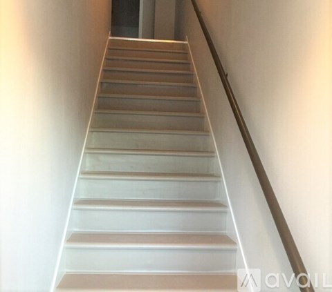 A staircase with a metal railing on the right side.