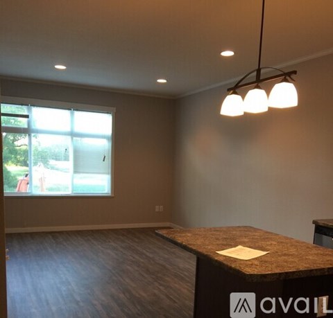 A room with a brown counter and a window with a view of trees and a person outside.
