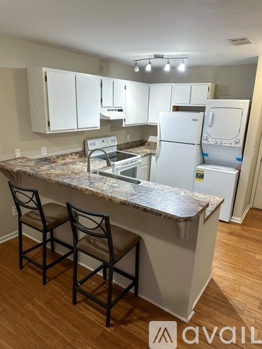 A kitchen with white cabinets and a granite countertop.