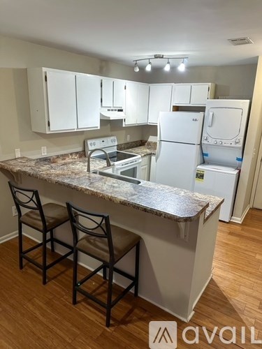 A kitchen with white cabinets and a granite countertop.