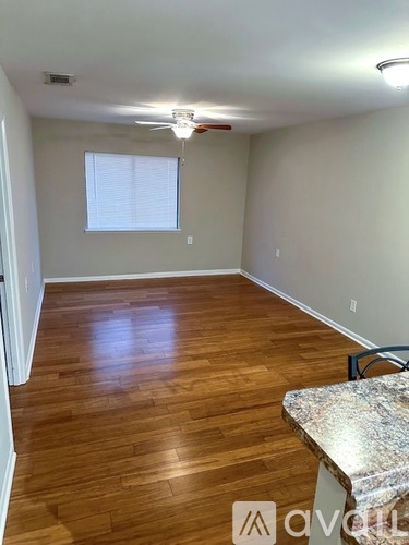 A room with wooden flooring and a ceiling fan.