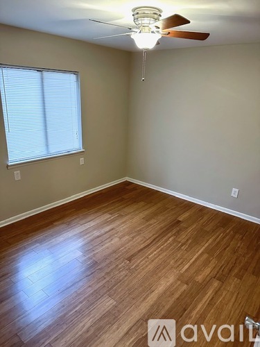 A room with wooden flooring and a ceiling fan.