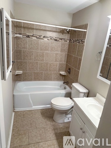 A bathroom with a tub, toilet, and sink.
