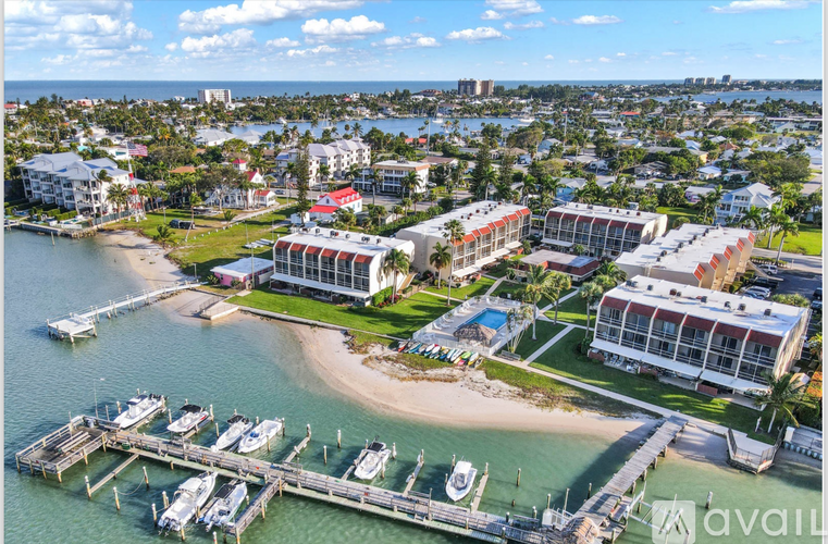 A marina with boats docked and a building with a red roof.