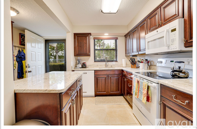 A kitchen with brown cabinets and a white counter.