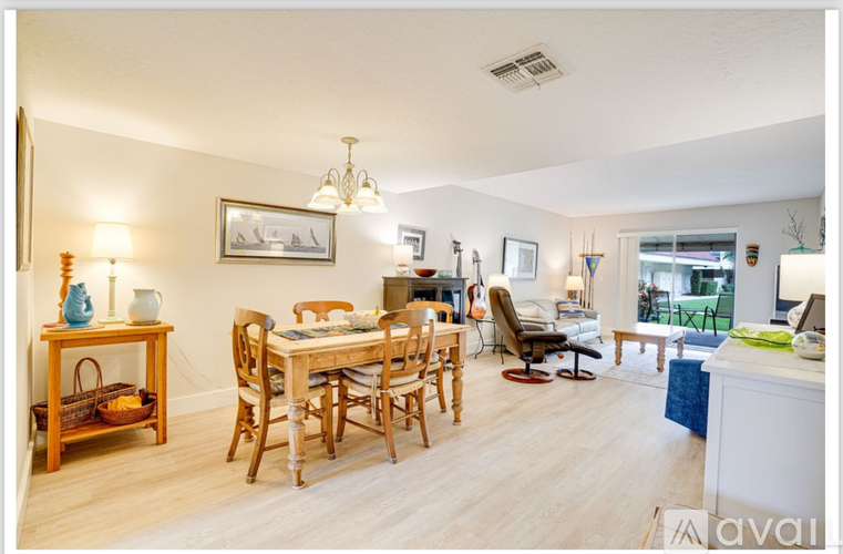A well-lit, spacious living room with a dining table and chairs.