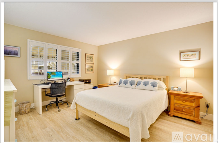 A bedroom with a bed, desk, and chair.