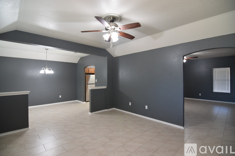 A spacious room with a ceiling fan and a cabinet in the corner.
