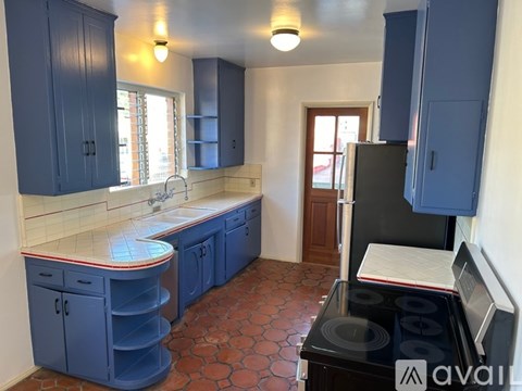A kitchen with blue cabinets and a black stove top.