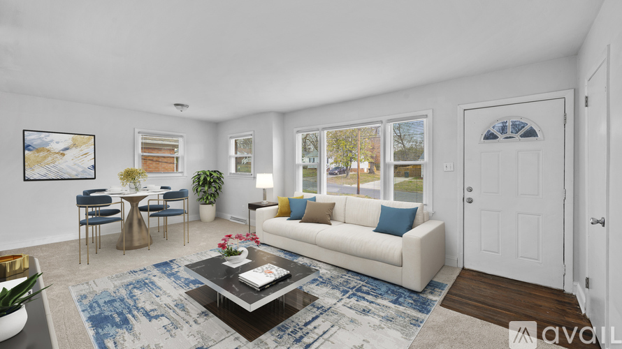 A living room with a white couch, a coffee table, and a painting on the wall.