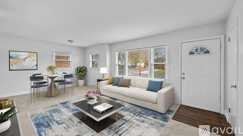 A living room with a white couch, a coffee table, and a painting on the wall.