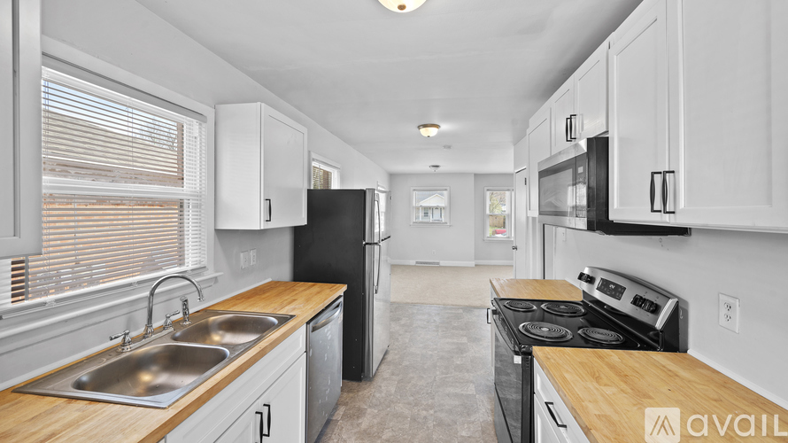 A kitchen with a sink, stove, and refrigerator.