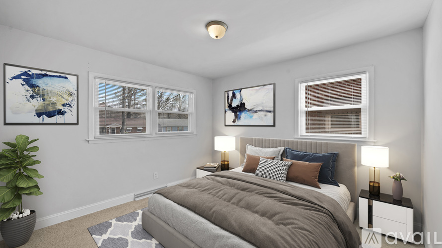 A bedroom with a bed, nightstand, and two framed pictures on the wall.