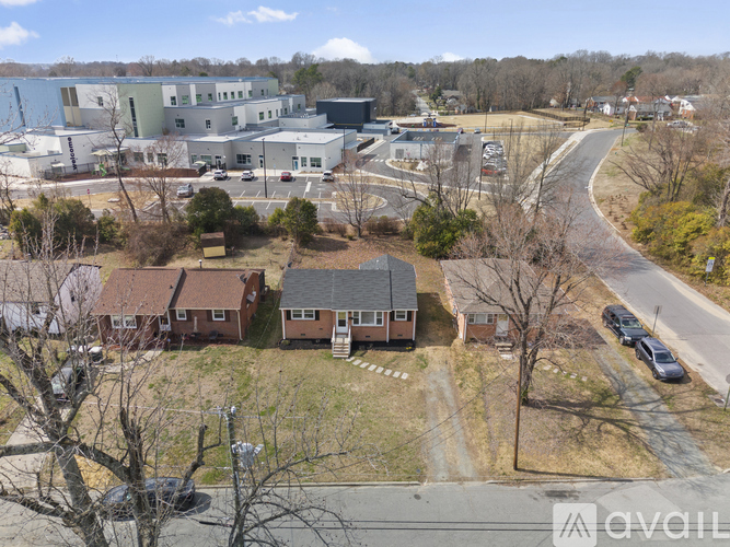 A large industrial building complex with a parking lot in front.