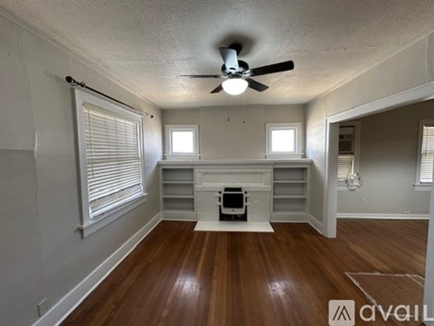 A room with a wood floor and a ceiling fan.