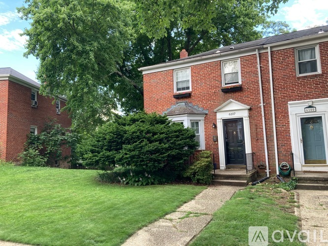 A red brick house with a green lawn in front.