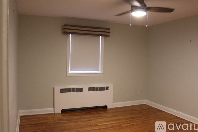 A room with a window, a fan, and a radiator.