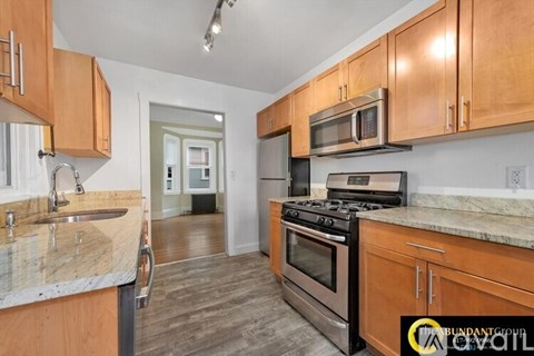 A kitchen with wooden cabinets and a stove top oven.