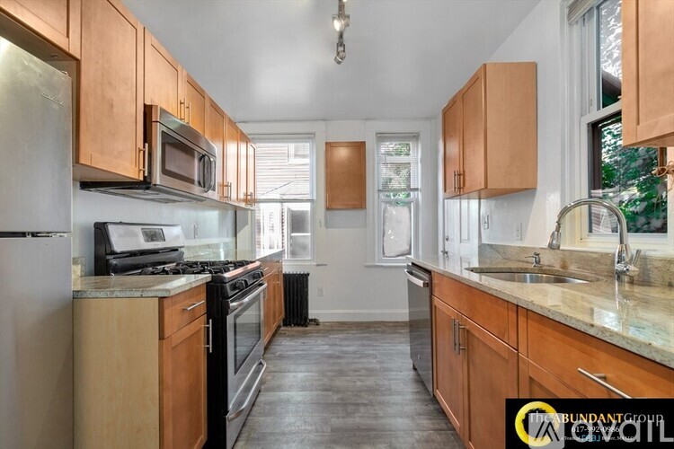 A kitchen with wooden cabinets and a granite countertop.