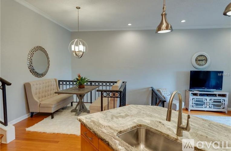 A kitchen with a beige sofa and a TV.