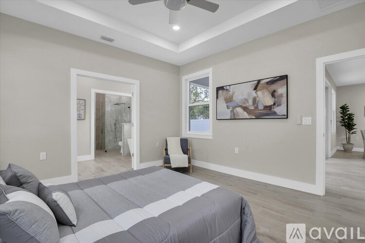 A bedroom with a large bed and a ceiling fan.