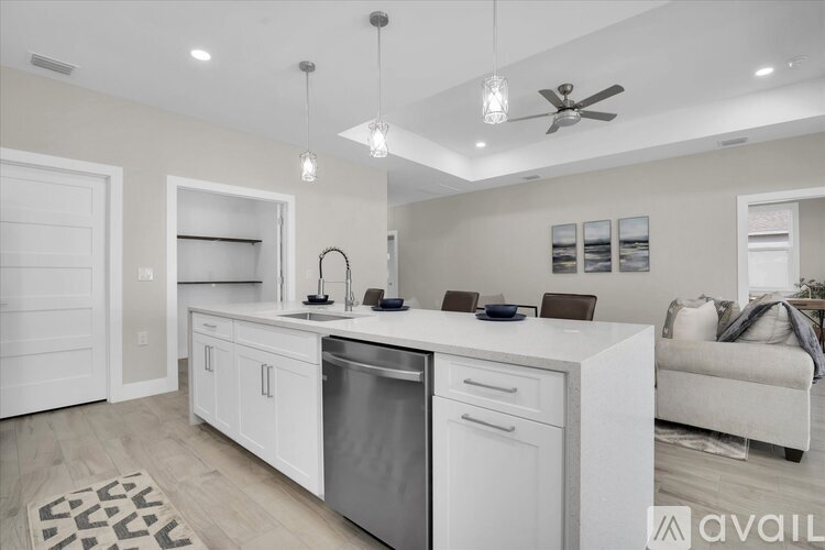 A modern kitchen with white cabinets and a stainless steel dishwasher.