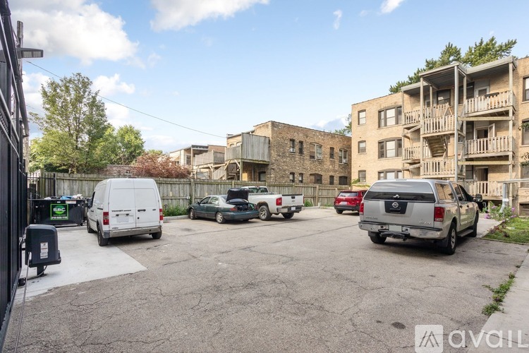 A parking lot with cars and apartment buildings in the background.