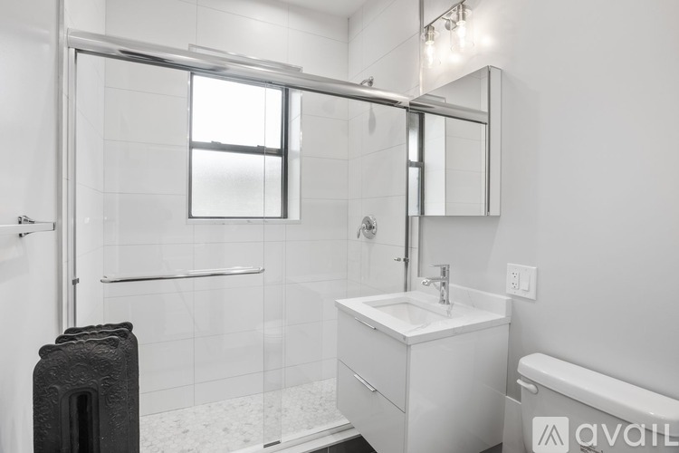 A bathroom with a white sink and a glass shower stall.