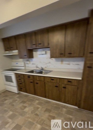 A kitchen with wooden cabinets and a white oven.