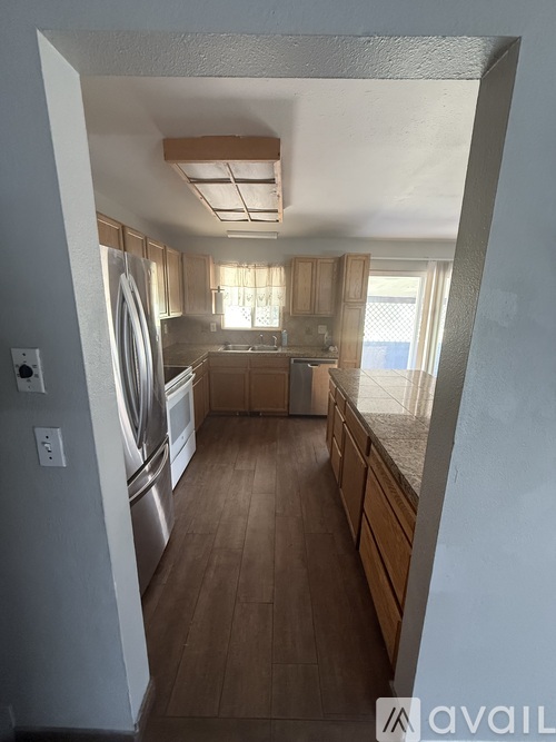 A kitchen with wooden floors and a washing machine.