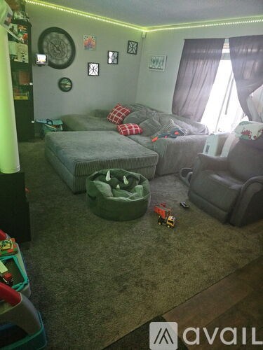A living room with a grey couch and a green ottoman.