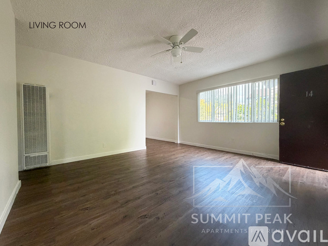 A living room with wood flooring and a ceiling fan.