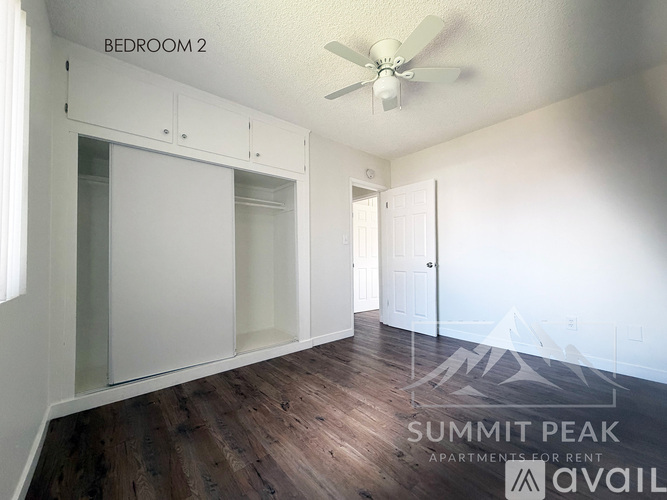 A parking lot in front of a building with the text "Summit Peak Apartments for Rent" on the image.