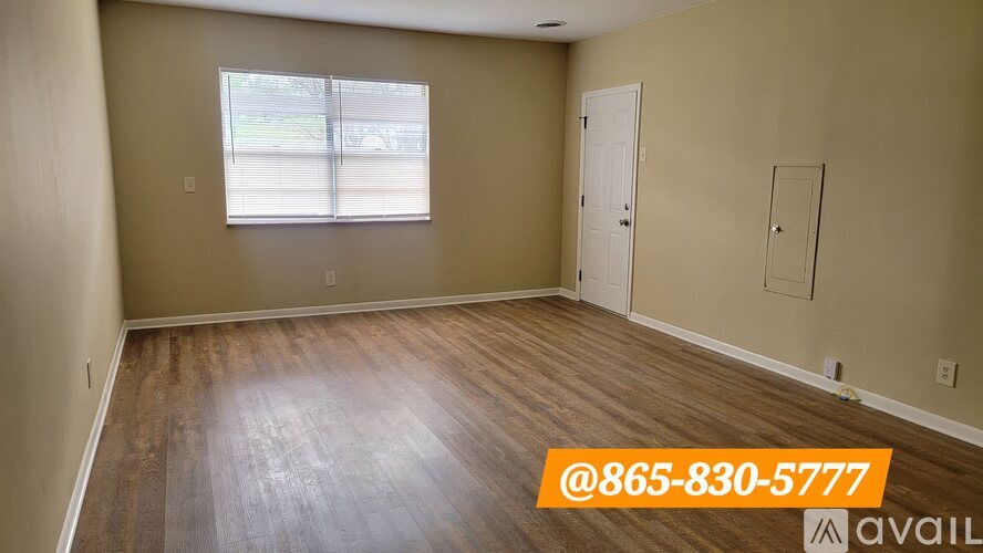 A room with a window and wooden flooring is available for rent or sale.