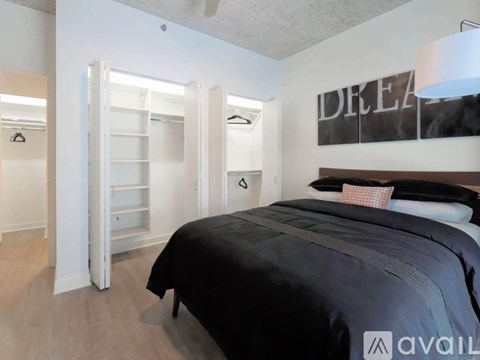A bedroom with a bed, a wardrobe, and a poster on the wall.