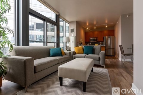A living room with a grey couch and a white ottoman.