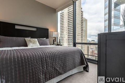 A bedroom with a large bed and a view of the city.