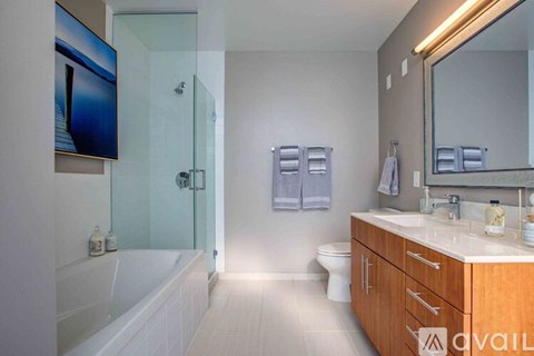 A bathroom with a glass shower door and a white bathtub.