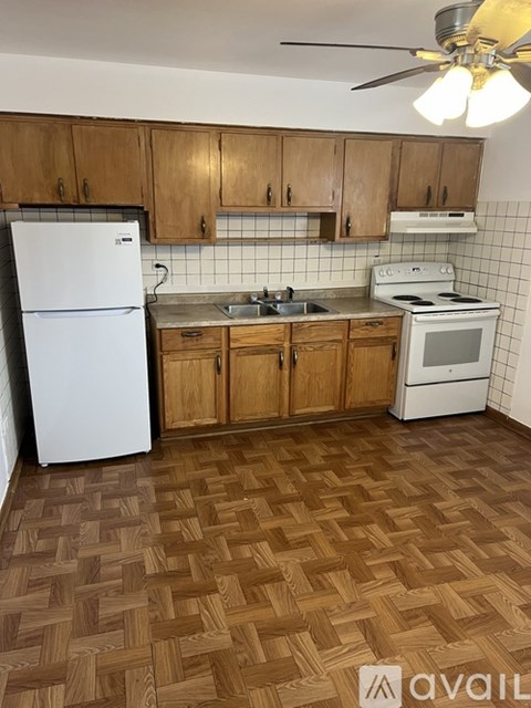A kitchen with wooden cabinets and a white fridge.