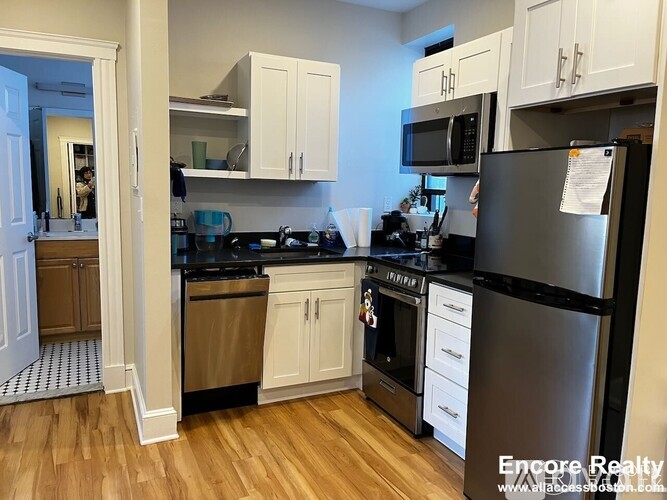 A kitchen with a refrigerator, stove, and oven.