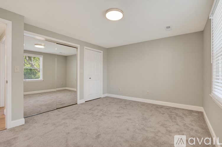 A spacious room with a carpeted floor and a ceiling light.