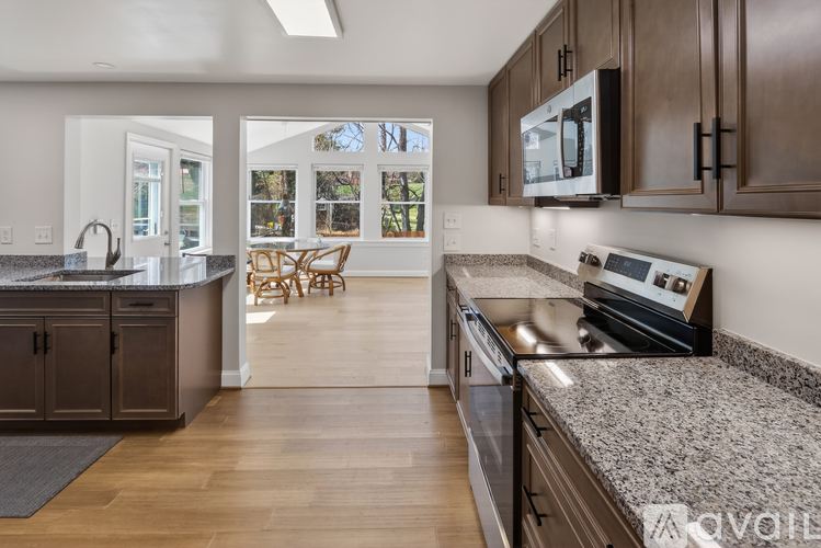 A kitchen with brown cabinets and a granite countertop.