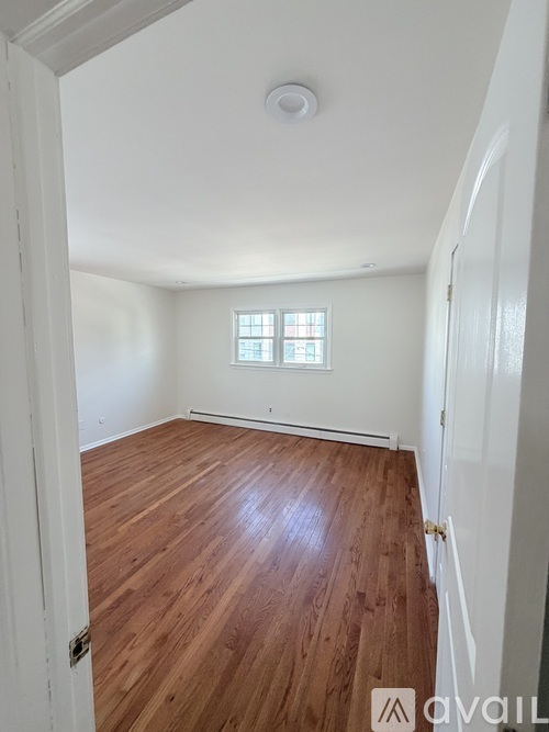 A room with wooden floors and a window.
