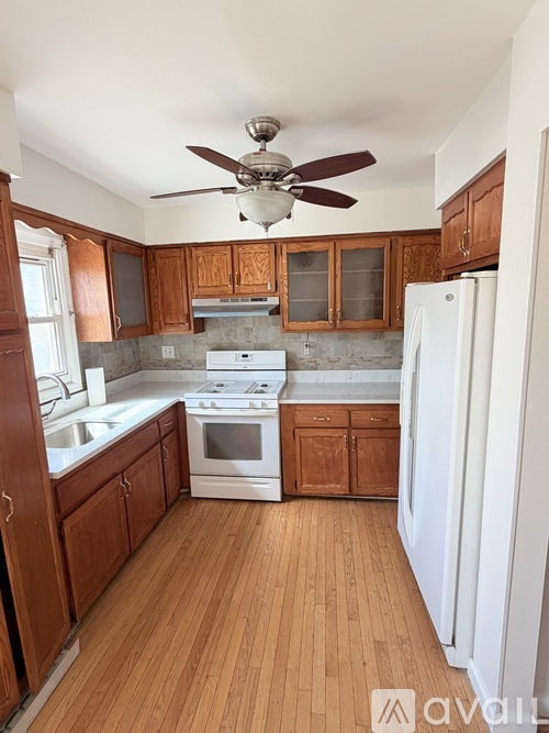 A kitchen with wooden cabinets and a white refrigerator.
