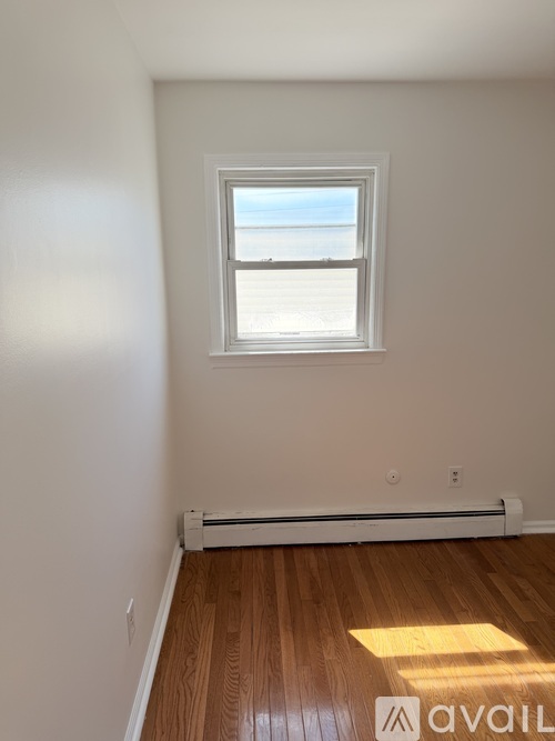 A room with a window and a radiator on the floor.