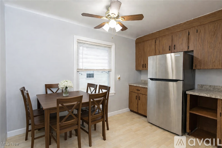 A kitchen with a table and chairs by a window.